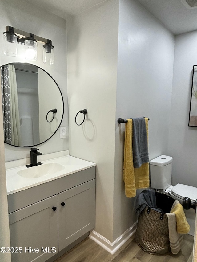 bathroom featuring hardwood / wood-style flooring, vanity, and toilet