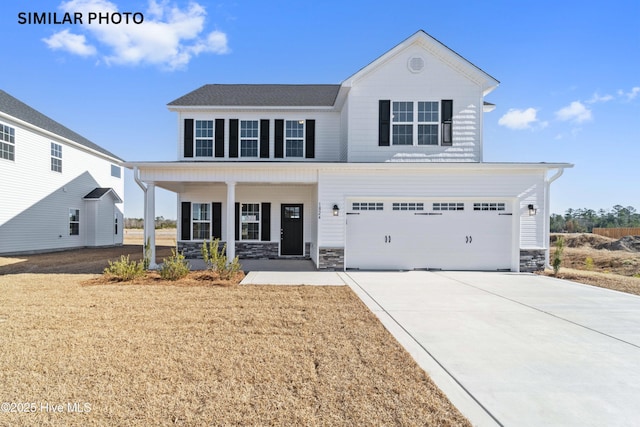 view of front facade with a garage, covered porch, and a front yard