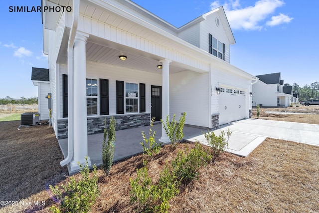 view of front of home featuring a garage and central air condition unit