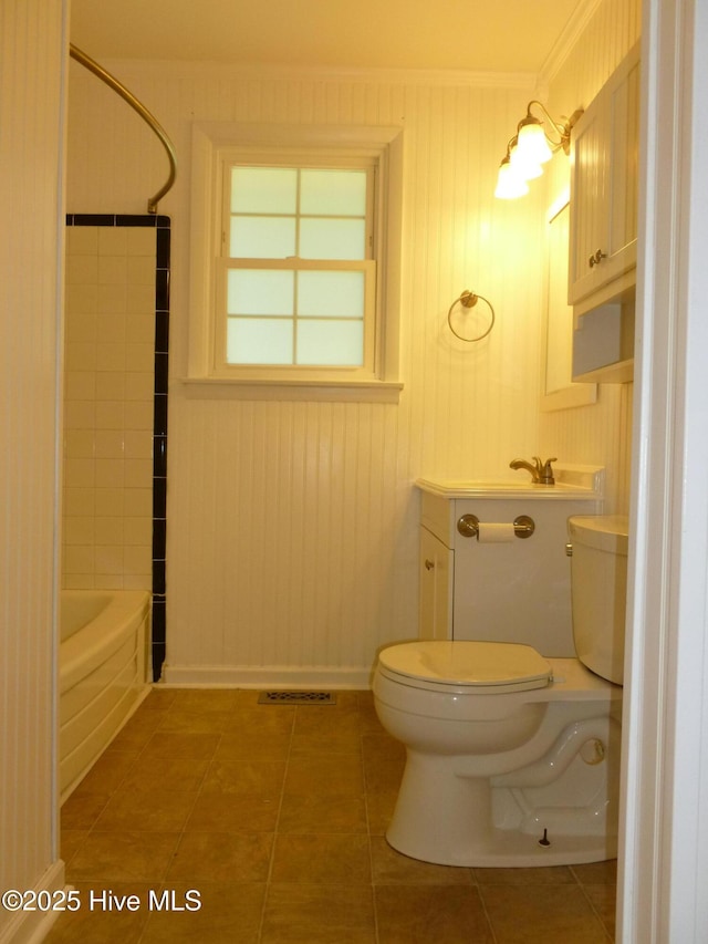 bathroom with toilet, tile patterned flooring, and tiled shower / bath