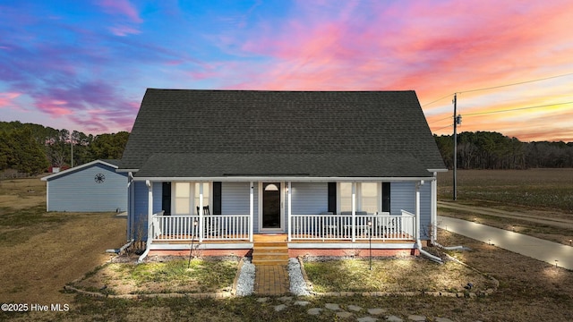 view of front of house featuring covered porch and a shingled roof