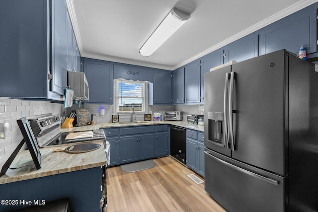 kitchen featuring blue cabinetry, appliances with stainless steel finishes, light countertops, and a sink