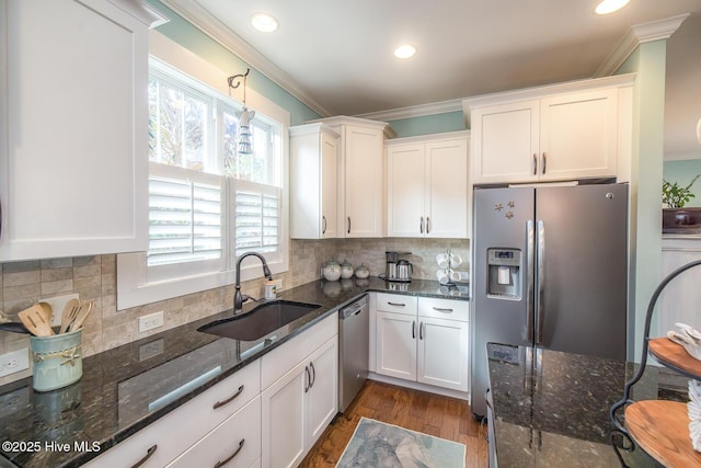 kitchen featuring appliances with stainless steel finishes, a sink, and white cabinets