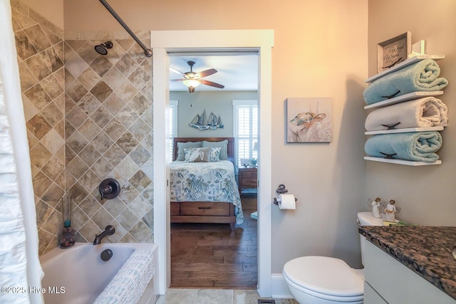 bathroom with ceiling fan, ensuite bathroom, toilet, vanity, and tiled shower / bath