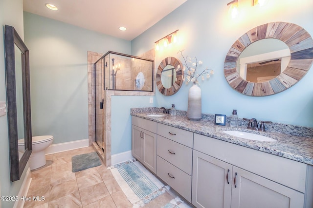 bathroom featuring double vanity, a shower stall, and a sink