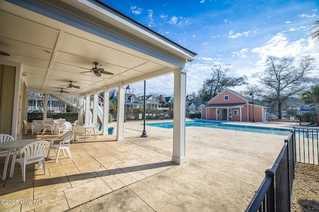 community pool featuring an outbuilding, a patio, ceiling fan, and an exterior structure