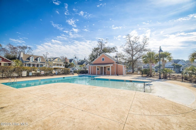 pool featuring a residential view, a patio area, and fence