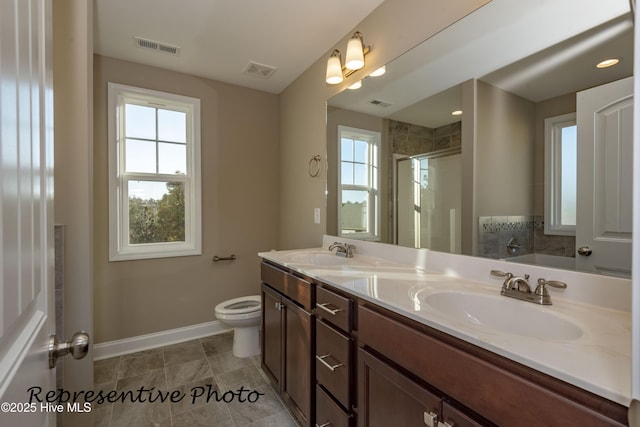 bathroom featuring baseboards, a shower stall, double vanity, and toilet