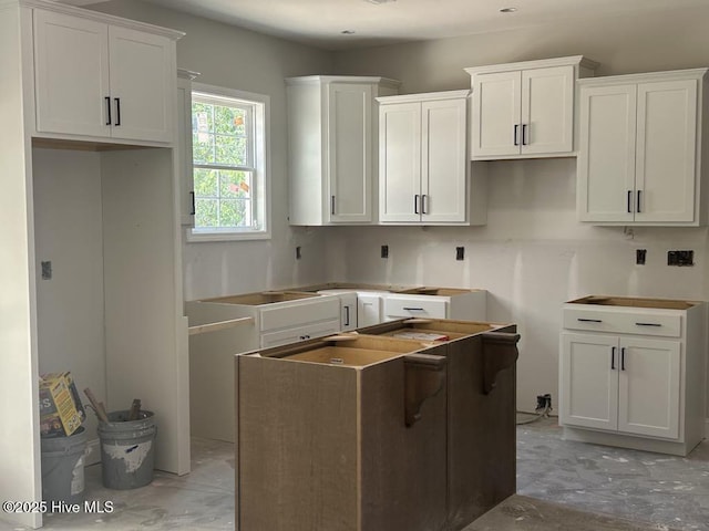 15661 Vista Point Ct, Wagram, NC 28396 - kitchen featuring a center island, white cabinets, and unfinished concrete flooring
