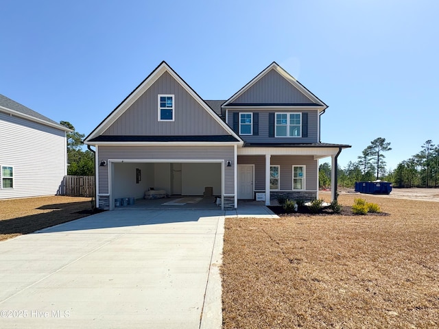 craftsman-style house with fence, covered porch, concrete driveway, a garage, and board and batten siding