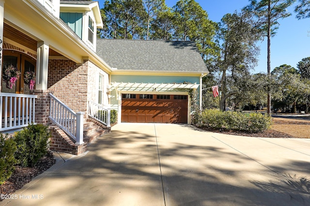 view of side of home with a garage, roof with shingles, concrete driveway, and brick siding