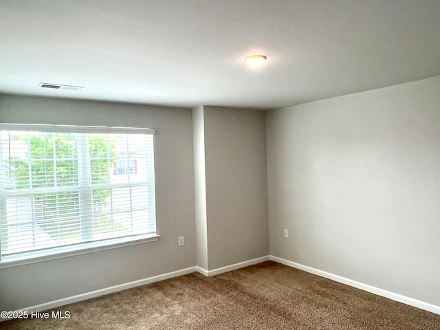 empty room with baseboards, carpet flooring, and visible vents