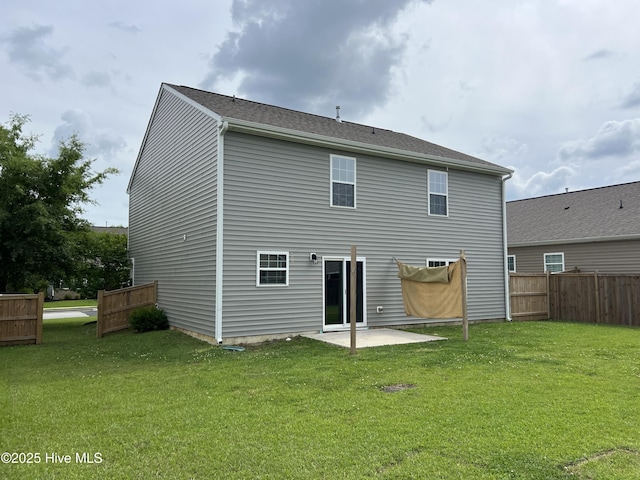 rear view of property with a patio, a lawn, and fence