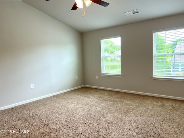 spare room featuring visible vents, carpet, ceiling fan, and baseboards