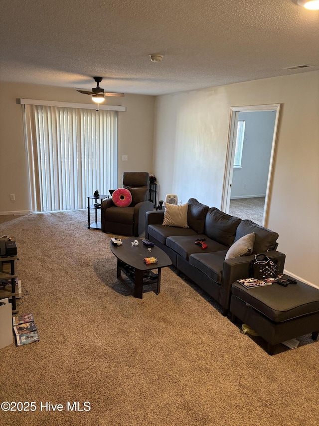 carpeted living room with ceiling fan and a textured ceiling