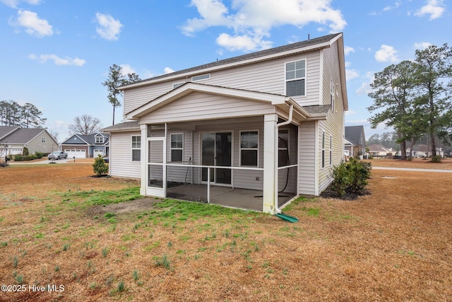 rear view of house with a patio area, a sunroom, and a lawn