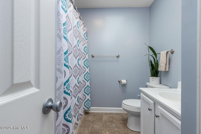 bathroom featuring curtained shower, toilet, vanity, tile patterned flooring, and baseboards