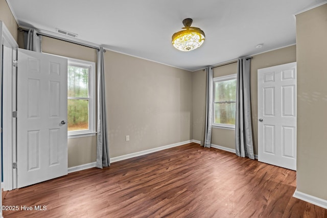 806 Wind Way, New Bern, NC 28560 - unfurnished bedroom with baseboards, visible vents, ornamental molding, and wood finished floors