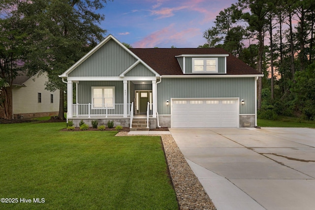 view of front of home featuring a garage, a lawn, and a porch