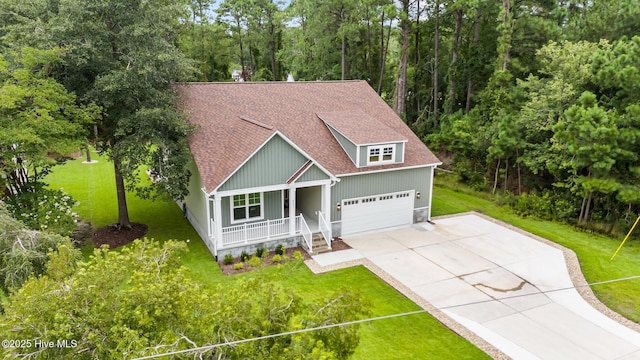 view of front of house with a garage, a front yard, and covered porch