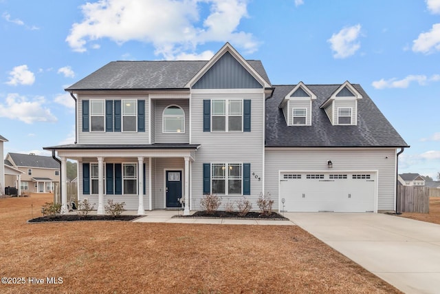 view of front of home featuring a garage, a front yard, and a porch