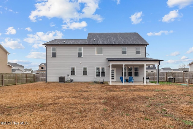 rear view of house featuring central AC, a patio area, and a lawn