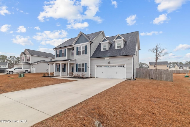 view of front of house with a garage, covered porch, and a front lawn