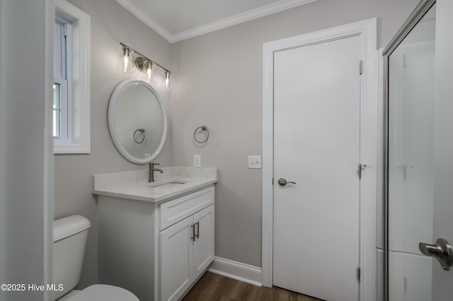 bathroom featuring hardwood / wood-style flooring, vanity, ornamental molding, and toilet