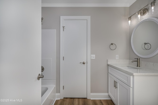 bathroom featuring vanity, crown molding, wood-type flooring, and  shower combination