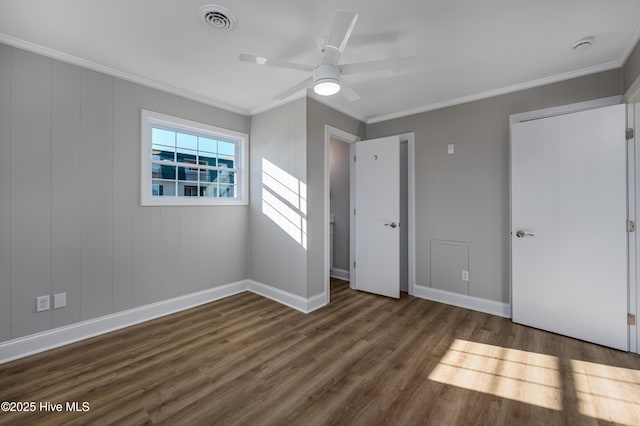 unfurnished bedroom with ceiling fan, ornamental molding, and dark hardwood / wood-style floors