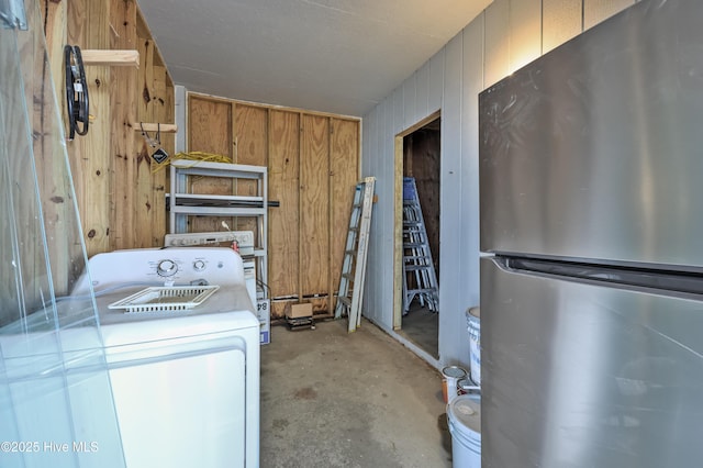 laundry area with wooden walls and washer / dryer