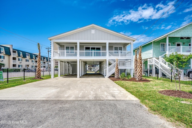 301 43rd Ave N, North Myrtle Beach, SC 29582 - raised beach house featuring covered porch, stairway, fence, a carport, and driveway
