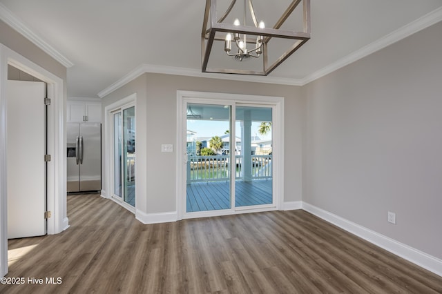 unfurnished dining area with crown molding, an inviting chandelier, and hardwood / wood-style floors