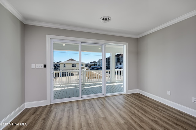 spare room with hardwood / wood-style floors and crown molding