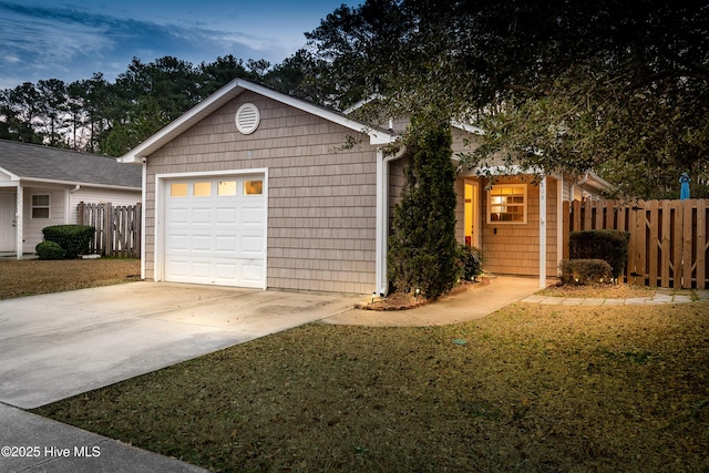 garage with concrete driveway and fence