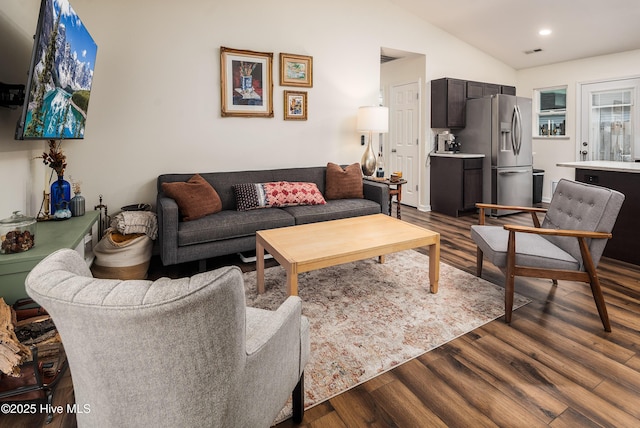 living room featuring vaulted ceiling, dark wood-type flooring, visible vents, and recessed lighting