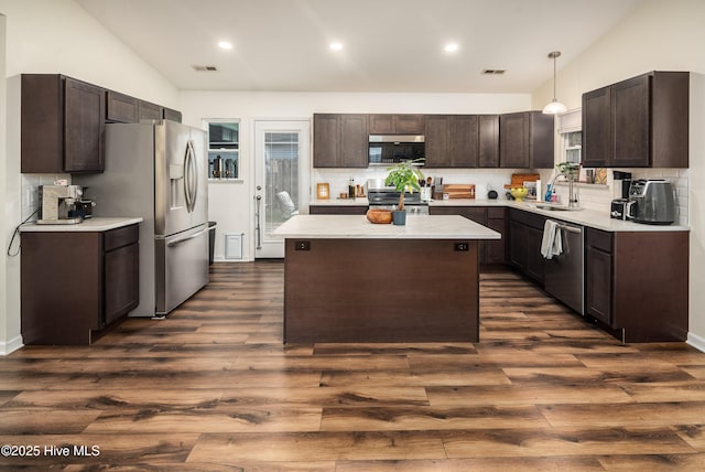 kitchen featuring dark brown cabinetry, visible vents, stainless steel appliances, and light countertops