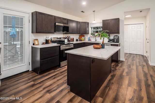 kitchen featuring visible vents, dark wood finished floors, lofted ceiling, appliances with stainless steel finishes, and dark brown cabinets