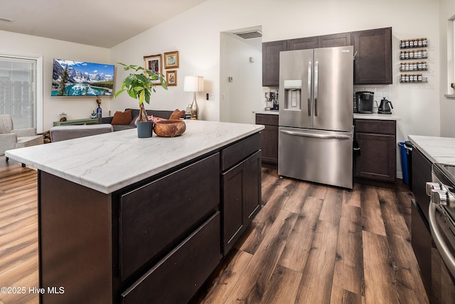 kitchen featuring vaulted ceiling, appliances with stainless steel finishes, dark wood finished floors, and dark brown cabinets