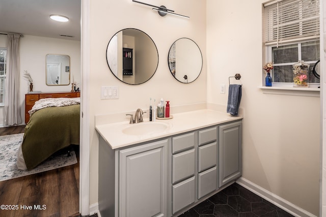 ensuite bathroom featuring visible vents, vanity, baseboards, and ensuite bathroom