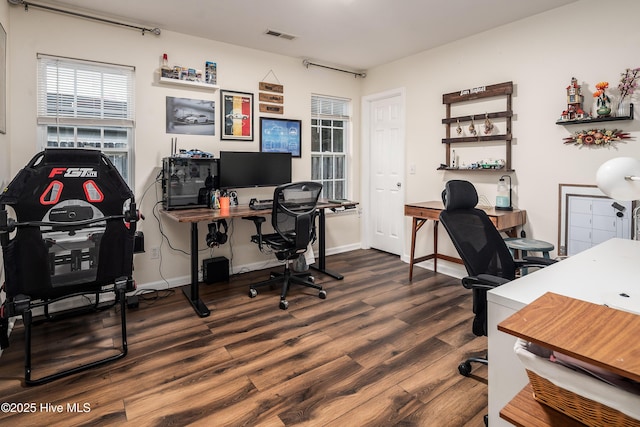 office space with dark wood-style floors, visible vents, and baseboards