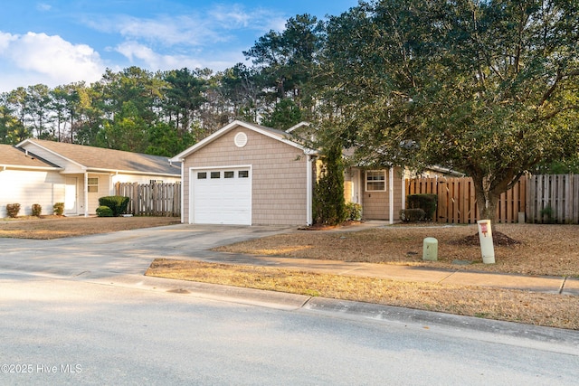 ranch-style house with driveway, a garage, and fence