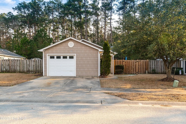 detached garage with fence and driveway