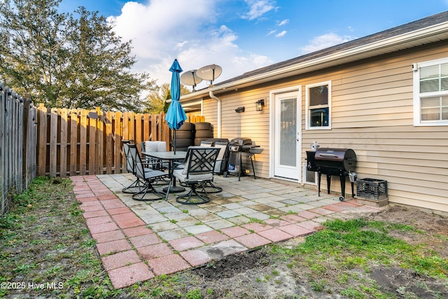 view of patio featuring outdoor dining area, grilling area, and a fenced backyard