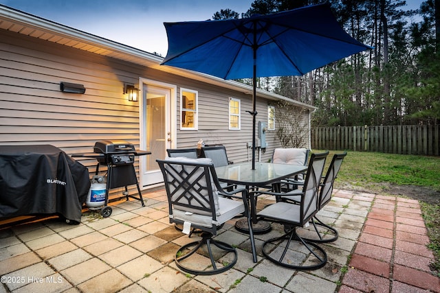 view of patio with outdoor dining space, a grill, and fence