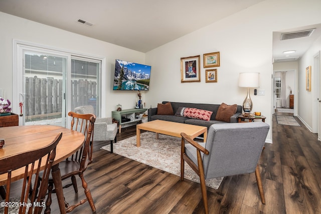 living room with lofted ceiling, dark wood finished floors, and visible vents