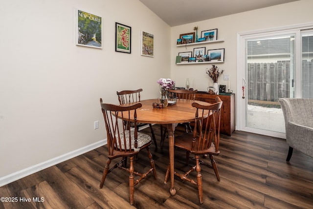 dining room featuring lofted ceiling, dark wood finished floors, and baseboards