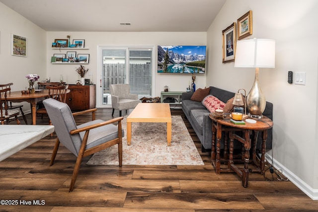 living area featuring wood finished floors, visible vents, and baseboards