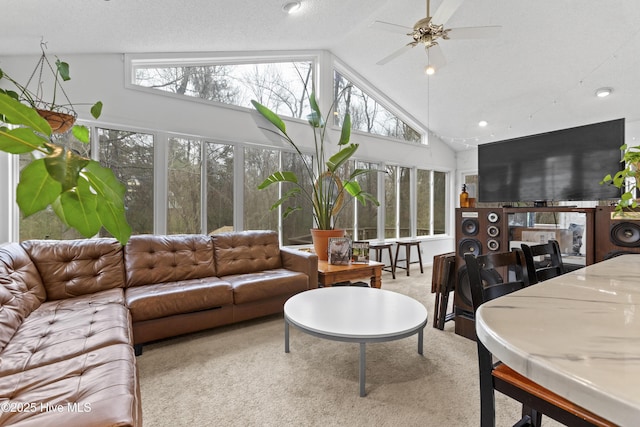 living room with high vaulted ceiling, ceiling fan, and carpet