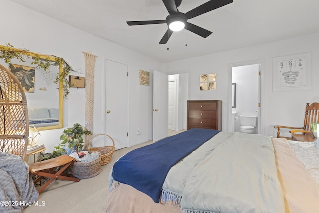 carpeted bedroom with ensuite bath and ceiling fan